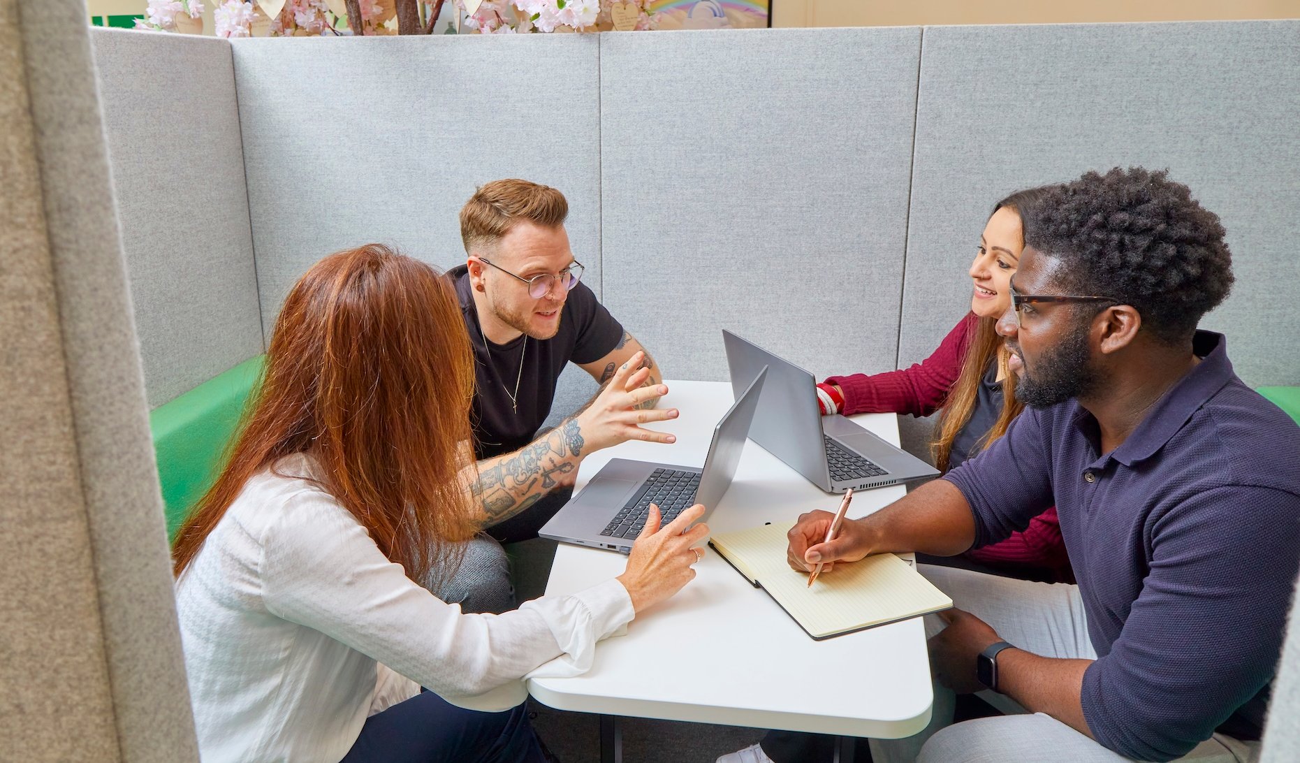 People working together, using laptops and writing.
